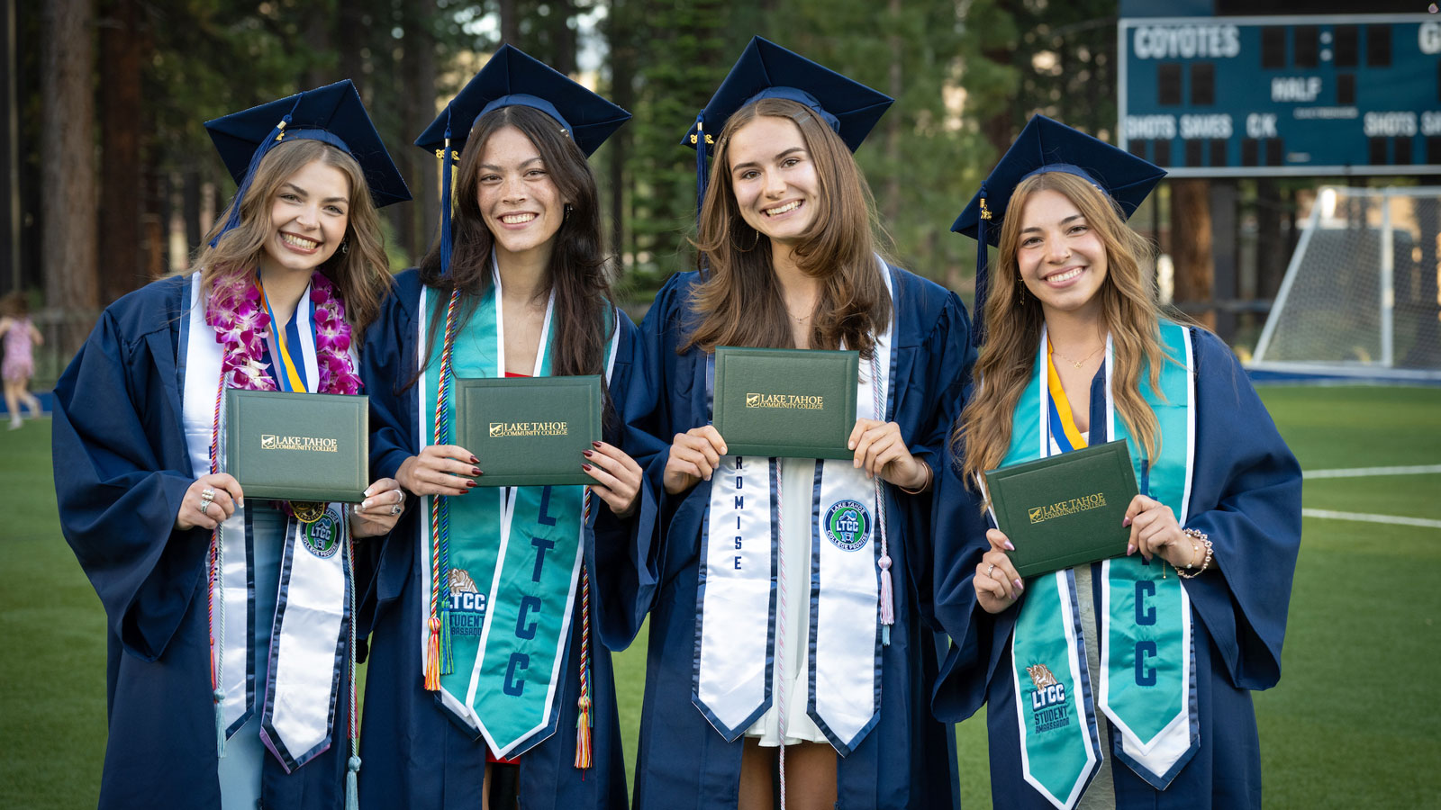 graduates holding diplomas