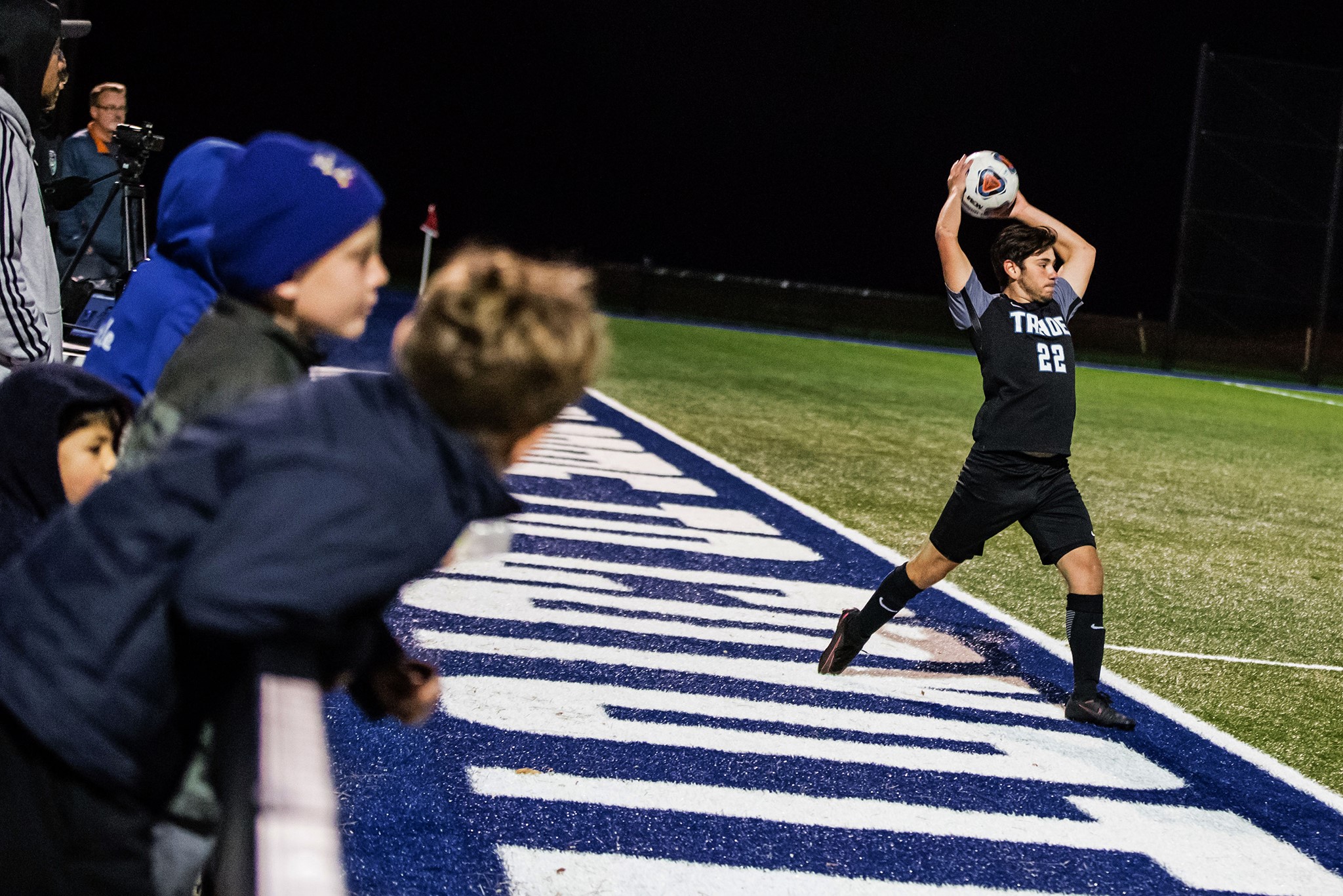 men's soccer player tossing ball in from the sideline