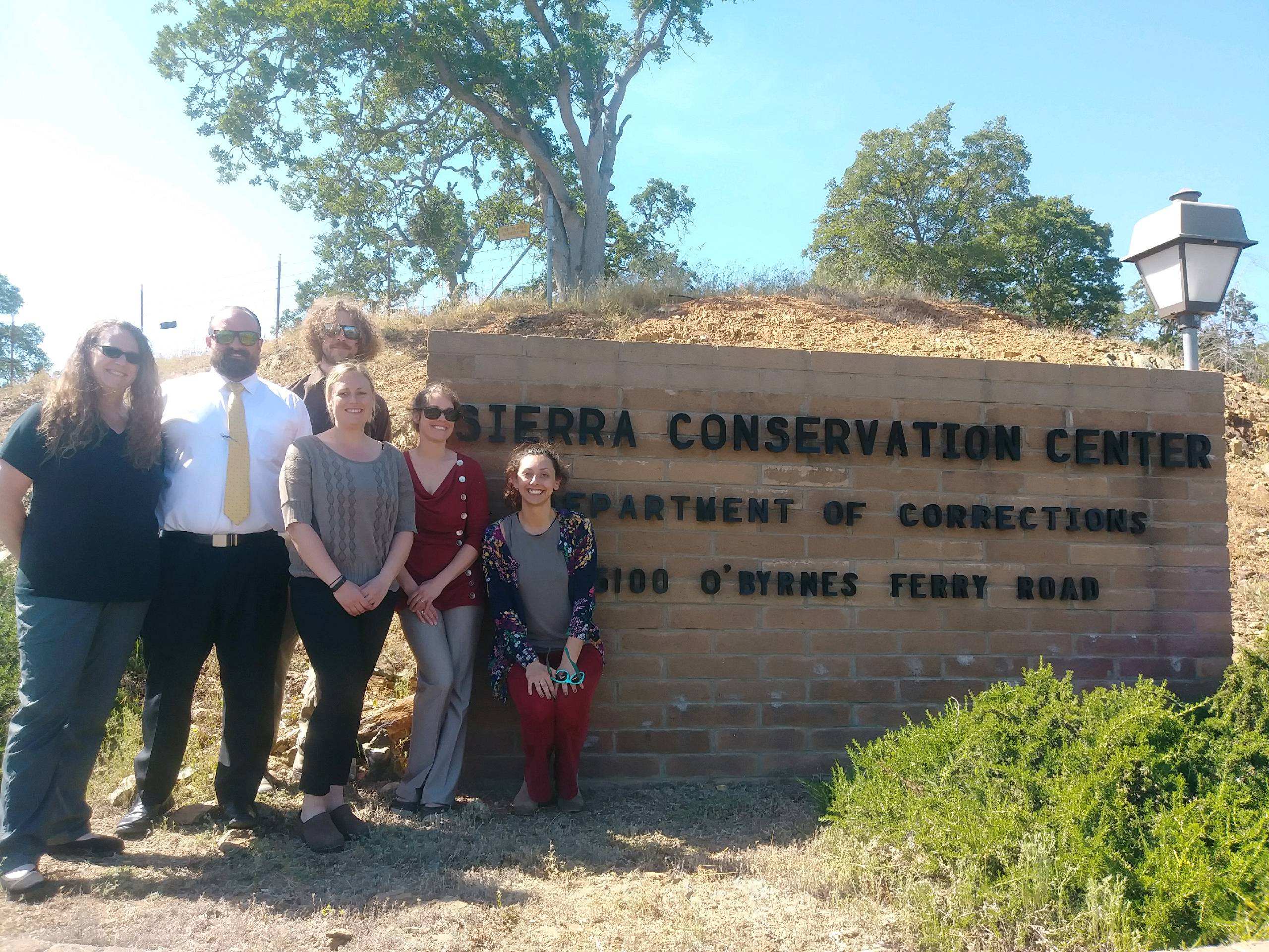 LTCC's Incarcerated Student Program staff in front of the Sierra Conservation Center sign