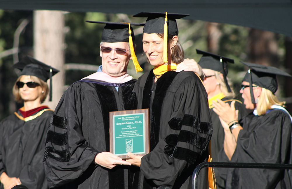 Dr. Mark Williams presents the Teacher of the Year Award to Dr. Sue Kloss at graduation