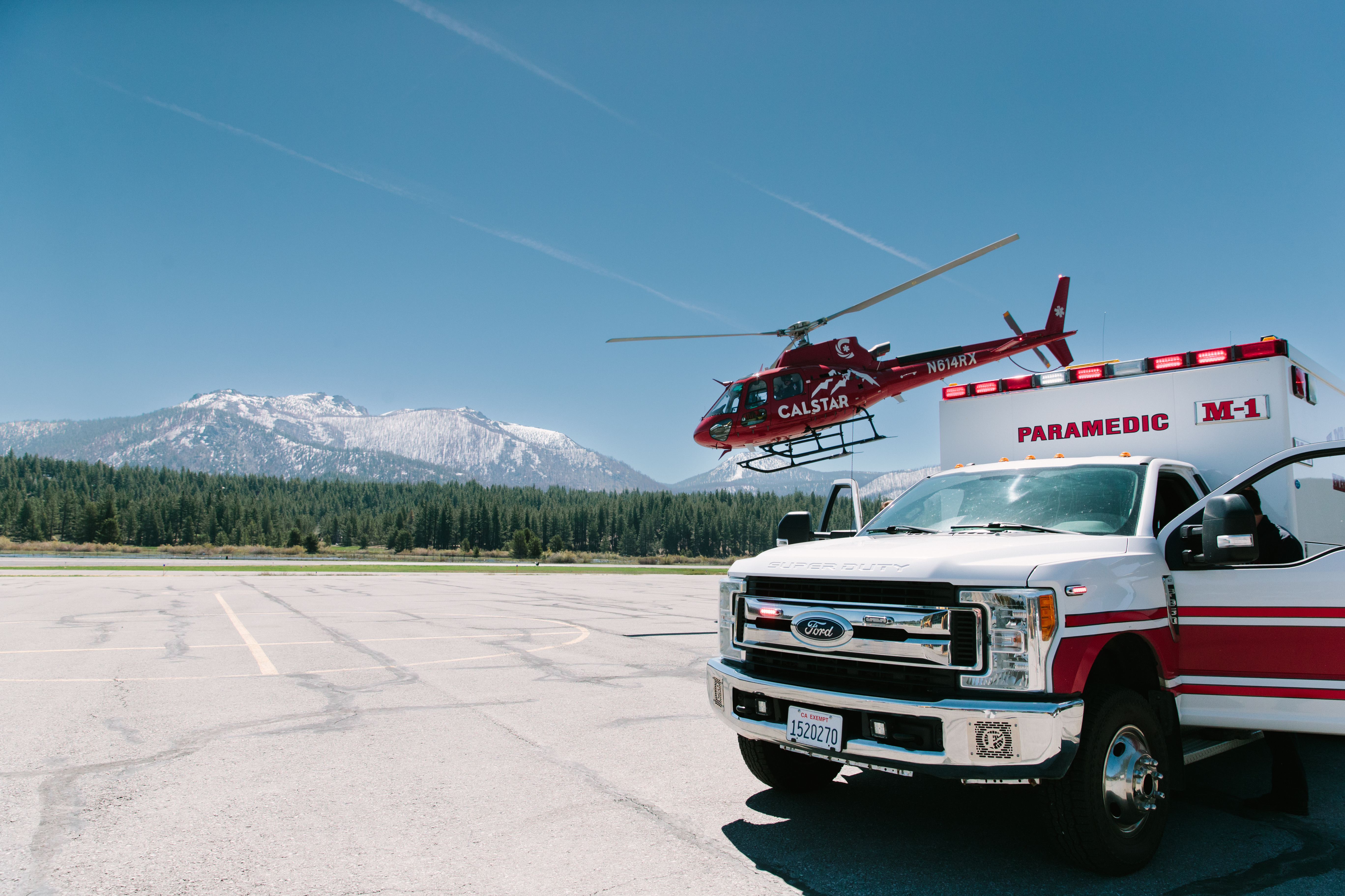 CalStar helicopter taking off from South Lake Tahoe Airport with ambulance in front