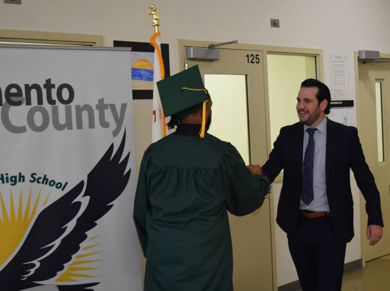 LTCC President Jeff DeFranco shakes the new graduate's hand